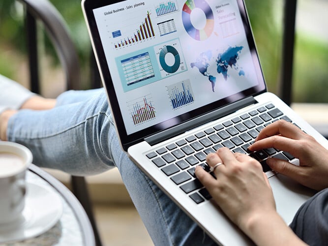 person som sitter og titter på statistikk på en laptop