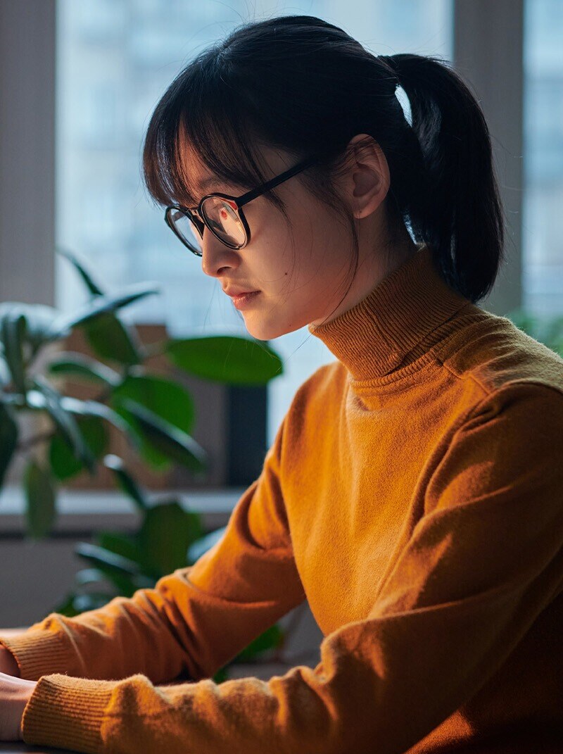 woman seen from the side typing on what seems like a keyboard